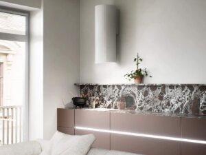 Biały okap kuchenny na tle marmurowej ściany.
